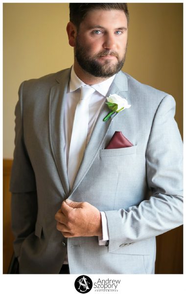 formal portrait photo of groom in window light