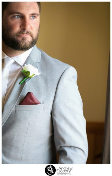 formal portrait photo of groom in window light