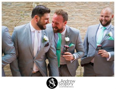 formal portrait photo of groom and groomsmen outside laughing