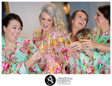 girls opening a bottle of champagne while laughing