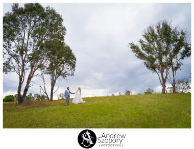 groom walks and leads bride down a hill together