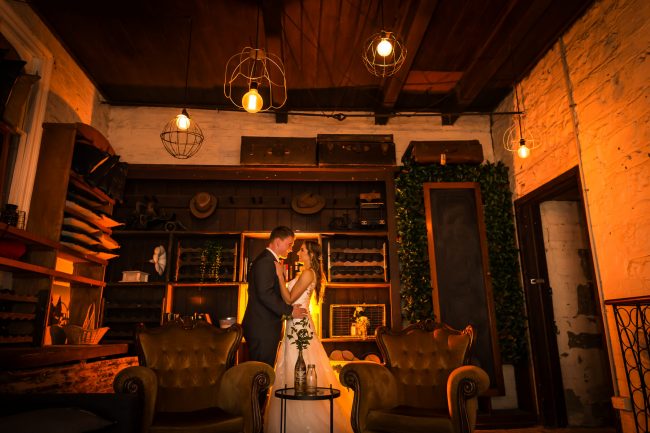 bride and groom in Barrell room at night at Gledswood, warm glow to photo