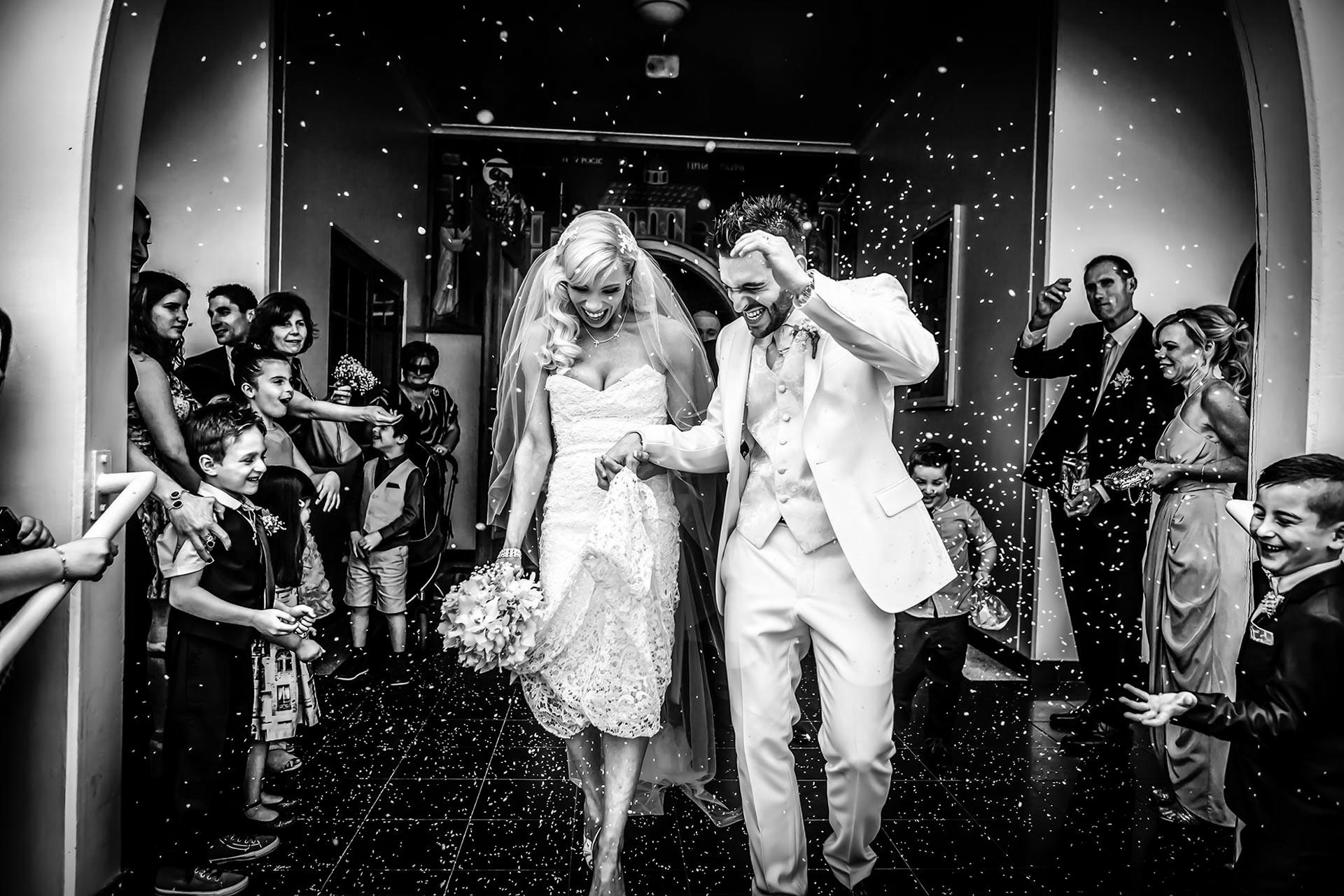 bride and groom leave church as guests throw rice at them 01 - Wollongong wedding photography